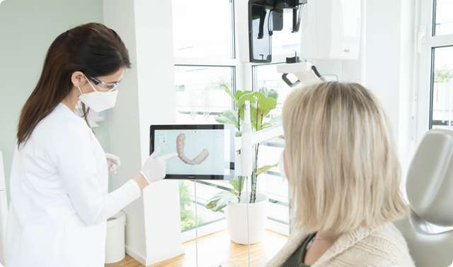 Zahnarzt zeigt Patienten 3D Simulation des Gebisses